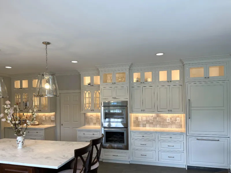 All white kitchen cabinets with stainless steel oven in the center.