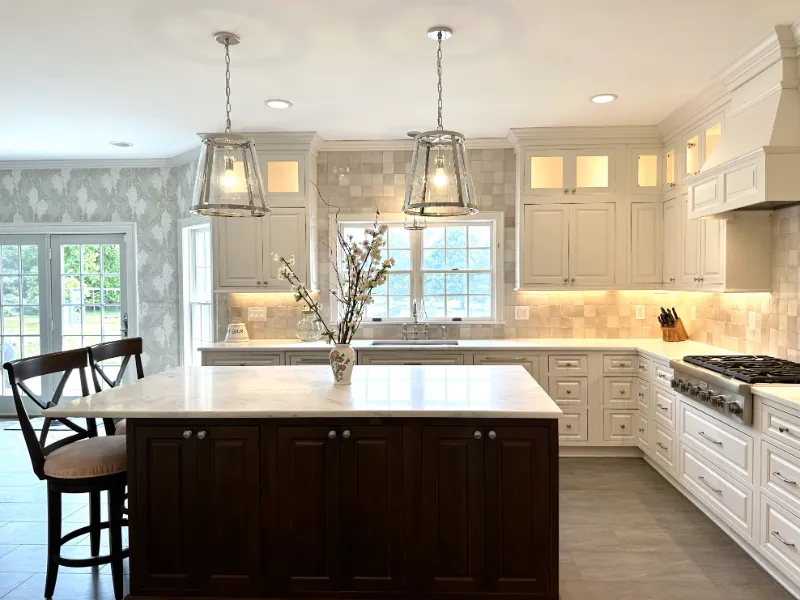 Kitchen island and cabinets and windows with sunlight shining in.